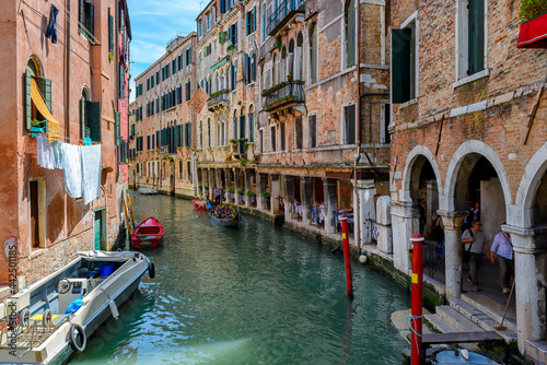 Narrow canal with gondola in Venice, Italy. Architecture and landmark of Venice. Cozy cityscape of Venice.