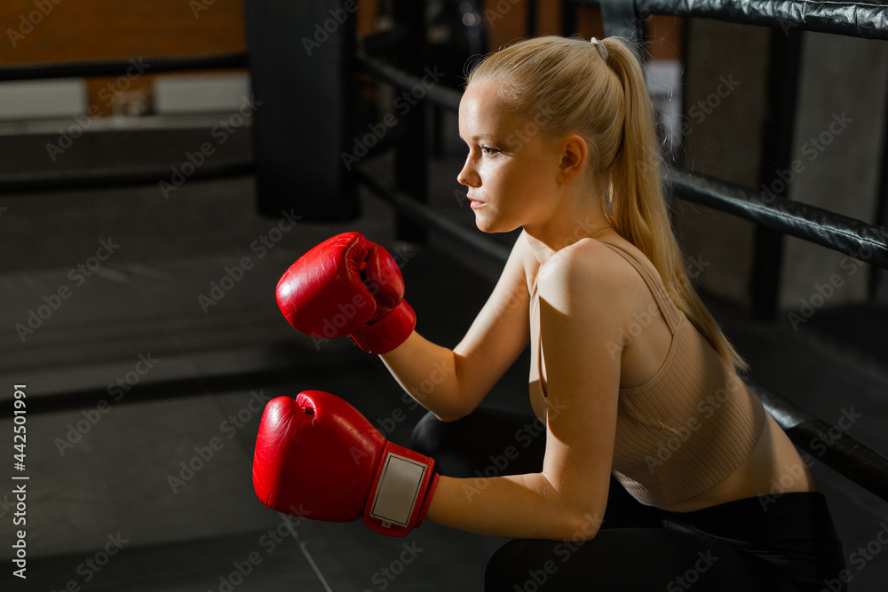 beautiful woman boxer in training in the ring	
