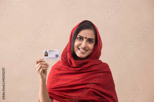 Portrait of a woman standing with her aadhar card. photo