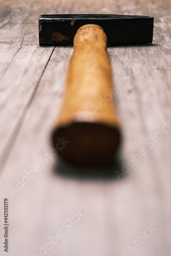Hammer with a wooden handle on an old board. Close-up. Selective focus. Space for lettering and design