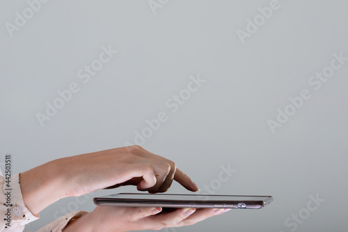 Close up of caucasian businesswoman using tablet, isolated on grey background