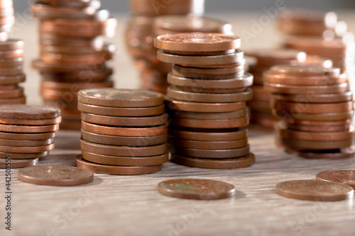 Close up of piles of coins on table, isolated on grey background