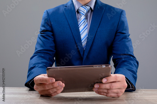 Midsection of caucasian businessman using tablet, isolated on grey background photo