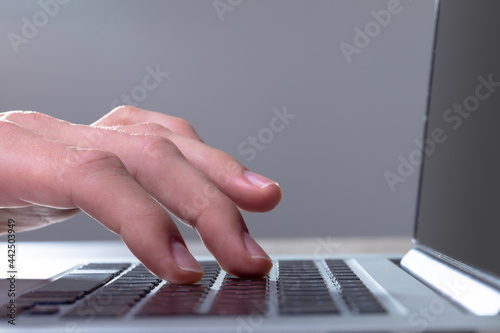 Close up of caucasian businessman typing on keyboard, isolated on grey background