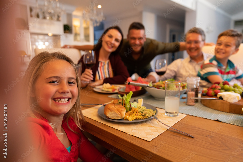 Caucasian couple with son and daughter and grandfather sitting at table eating together at home