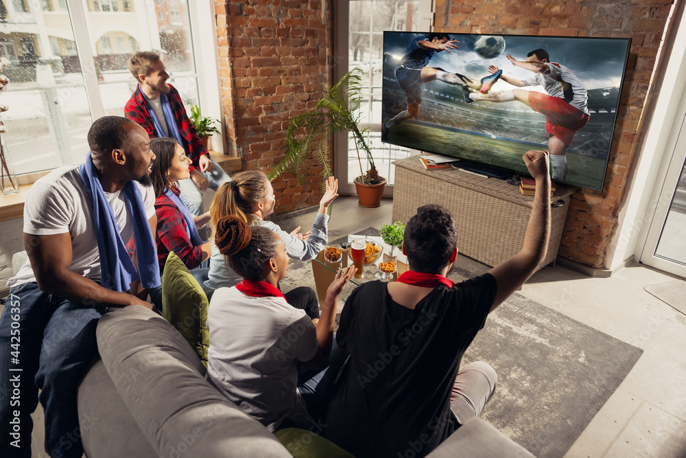 Fototapeta premium Leisure time. Excited, happy big group of young people watching sport match together on the couch at home.