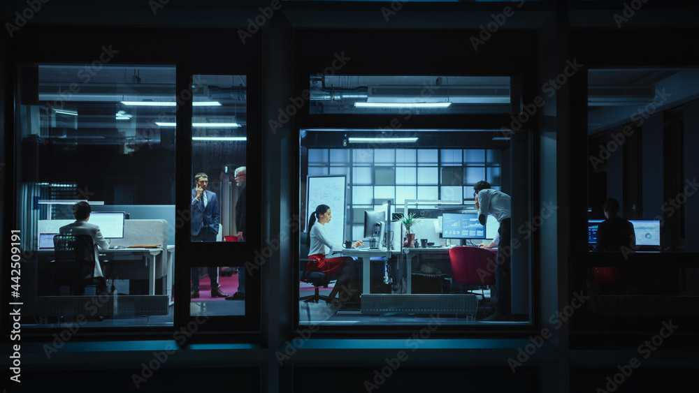 Shot from Outside: Businessman Working on a Digital Tablet Computer in the Office. Manager Checking Emails while Standing by the Window. Employee Planning Financial Tasks and Business Development.