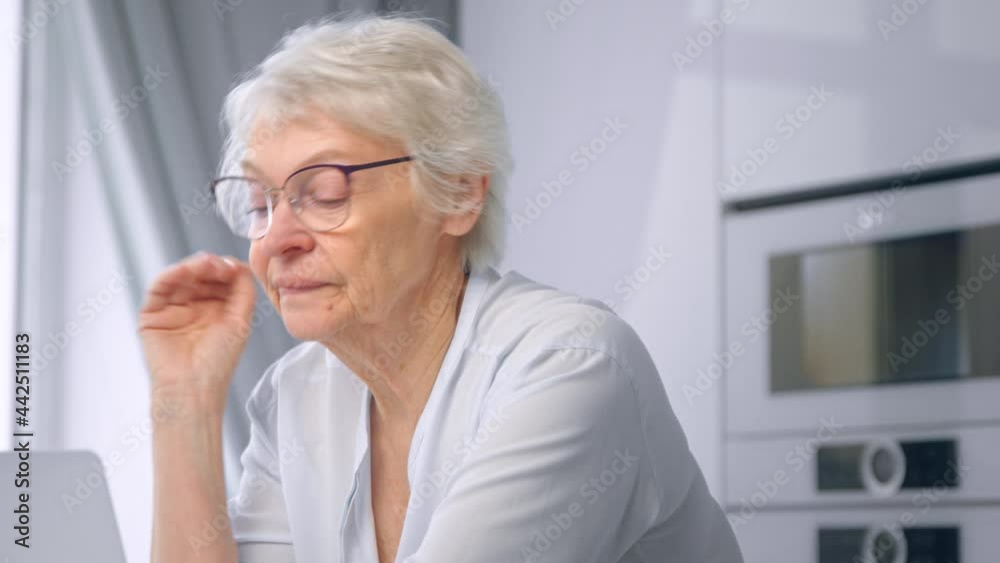 Serious old businesswoman with grey hair takes off glasses Serious old businesswoman with grey hair takes off glasses