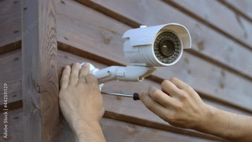 Technician installing wireless CCTV camera security system at house. Concept of surveillance and monitoring.