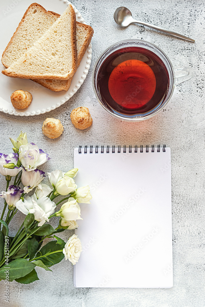 A blank notepad sheet with breakfast setting and flowers A blank notepad sheet with breakfast setting and flowers
