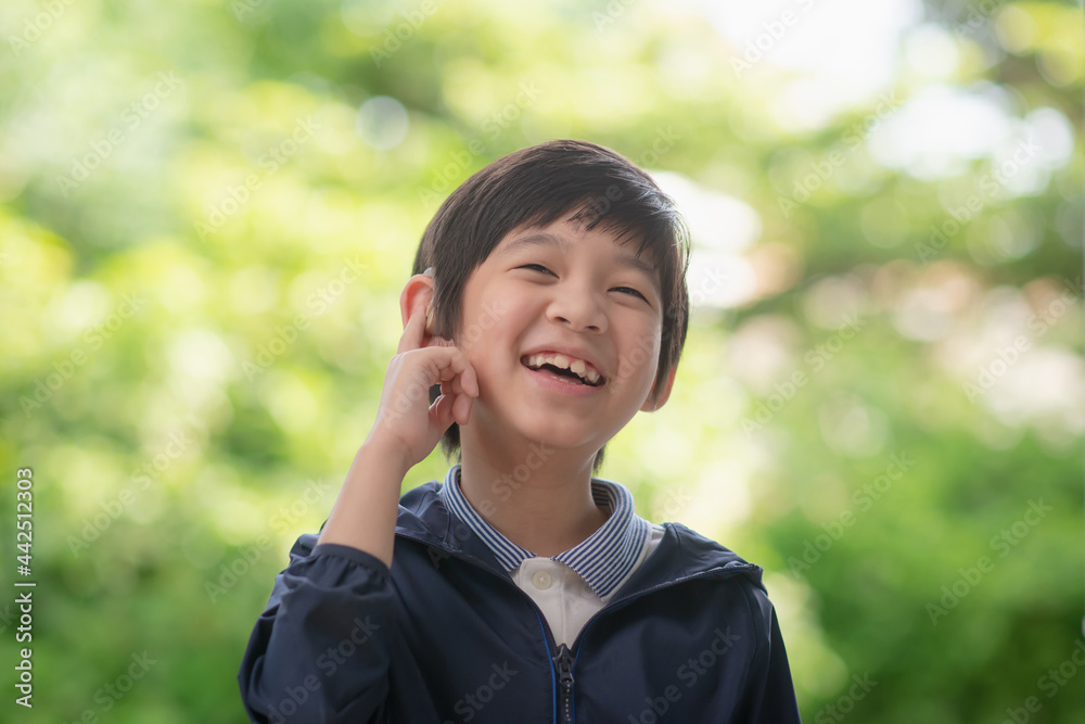 Asian child with hearing aid on nature background Asian child with hearing aid on nature background