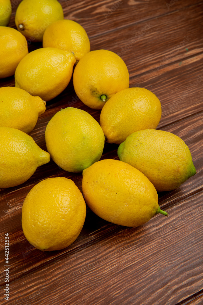 side view of fresh ripe lemons isolated on rustic wooden background with copy space