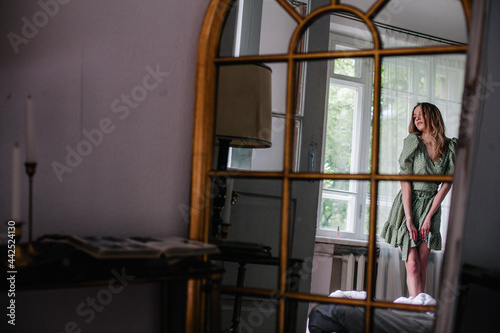 Young, slender girl reflected in an old mirror © Denis