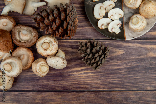 top view of fresh mushrooms and cones on rustic wooden background