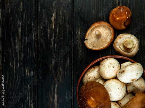 top view of fresh mushrooms in a bowl on dark wooden background with copy space