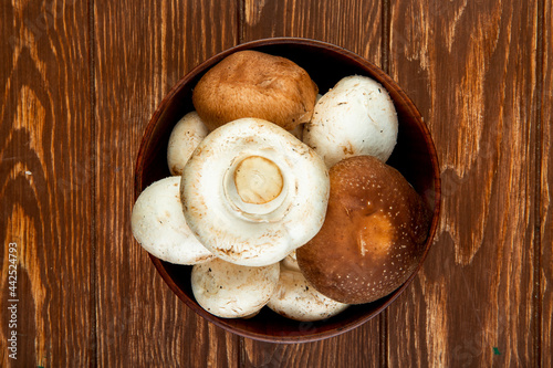 top view of fresh mushrooms in a wooden bowl on rustic background