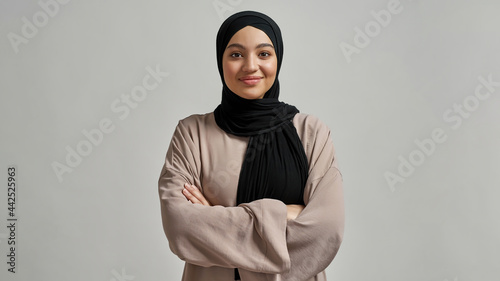 Fotografering Portrait of smiling young arabian girl in black hijab