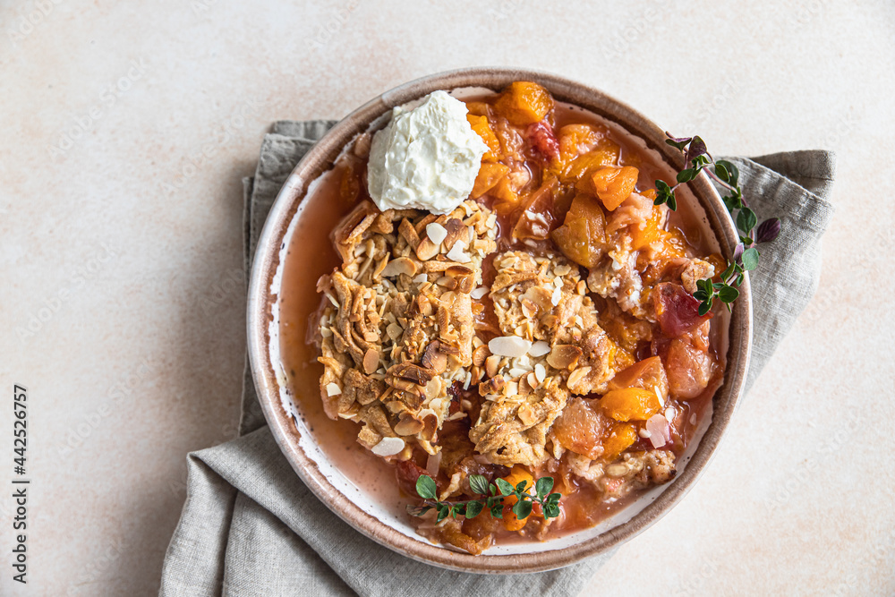 Ceramic plate with tasty plum crumble dessert served with vanilla ice cream and herbs. Top view. Ceramic plate with tasty plum crumble dessert served with vanilla ice cream and herbs. Top view.