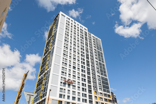 A high-rise building is under construction. metal and concrete structures. A sunny summer day.