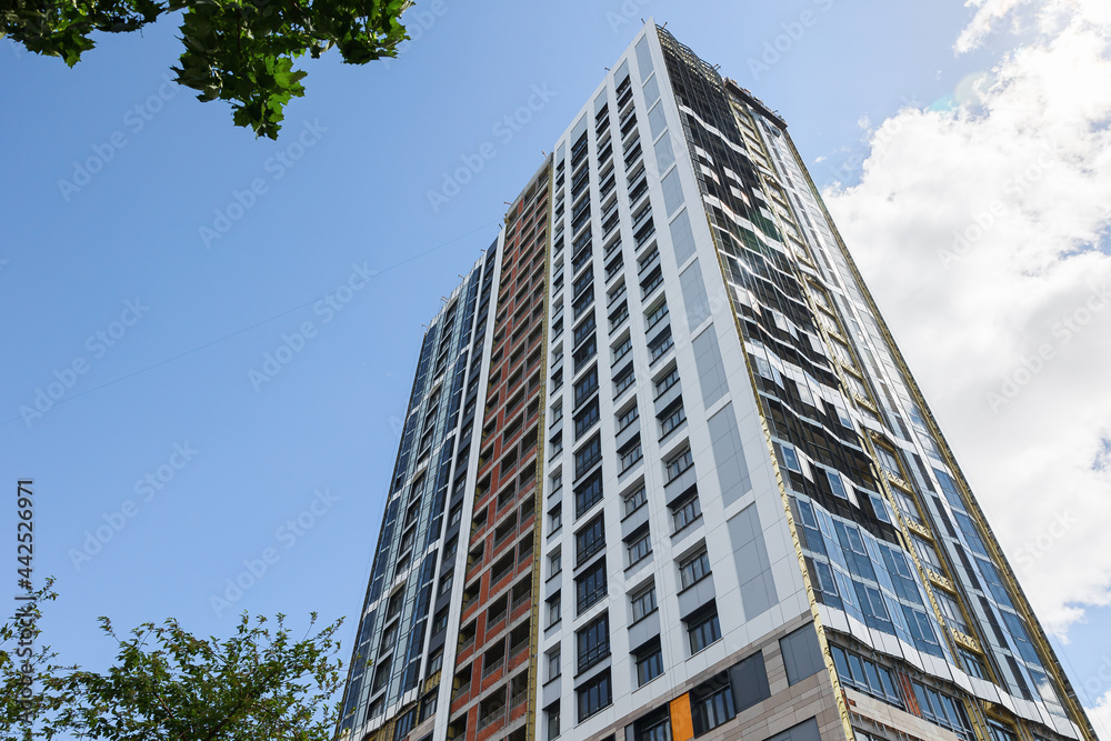 A high-rise building is under construction. metal and concrete structures. A sunny summer day.