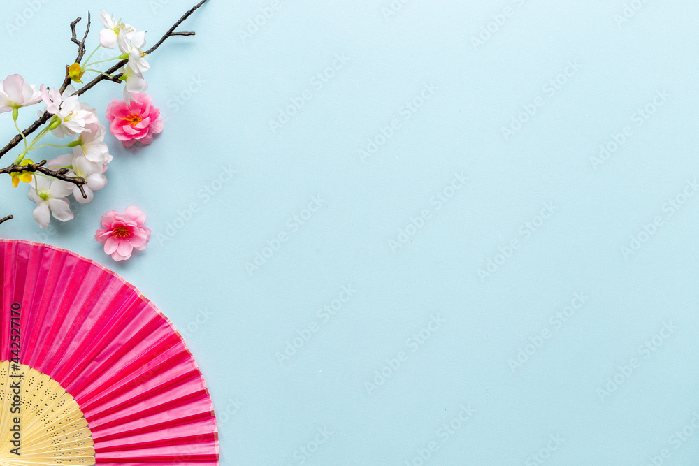 Japanese hand fan with cherry blossom branch. Top view