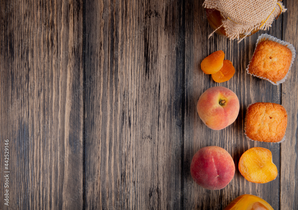 top view of fresh ripe peaches with muffins and peach jam in a glass jar on rustic wooden background with copy space top view of fresh ripe peaches with muffins and peach jam in a glass jar on rustic wooden background with copy space