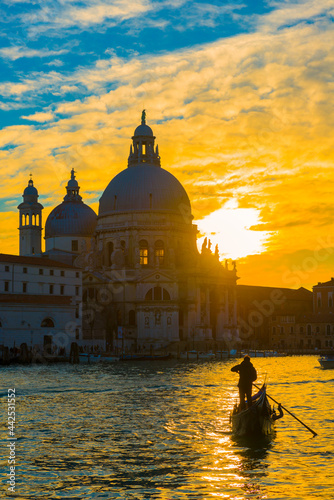 Gondolieri on Grand Canal and Church Salute in Sunset in Venice, Italy.