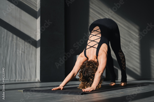 Young woman practicing yoga poses in an urban background on sunny day