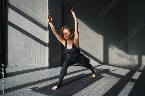 Fototapeta Naklejka Na Ścianę i Meble -  Young woman practicing yoga poses in an urban background on sunny day