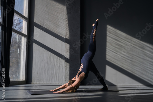 Young woman practicing yoga poses in an urban background on sunny day