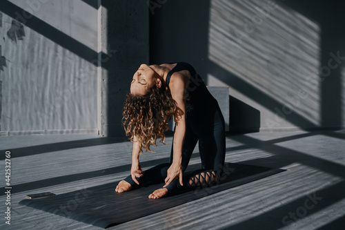 Young woman practicing yoga poses in an urban background on sunny day