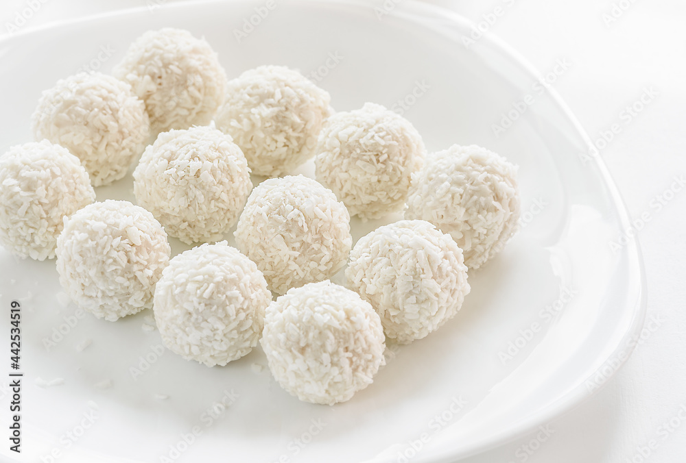 White sweet coconut truffles Closeup on white background, selective focus.