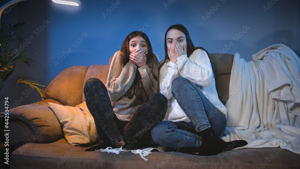 Two girls got scared while watching scary horror movie on TV at night