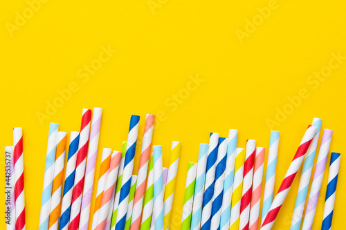 Biodegradable paper eco straws. Zero waste straws on yellow background. Top view.