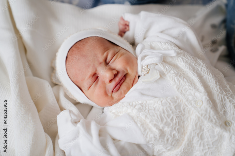 crying Newborn baby sleeps in white clothes. attire for discharge from hospital. crying Newborn baby sleeps in white clothes. attire for discharge from hospital.