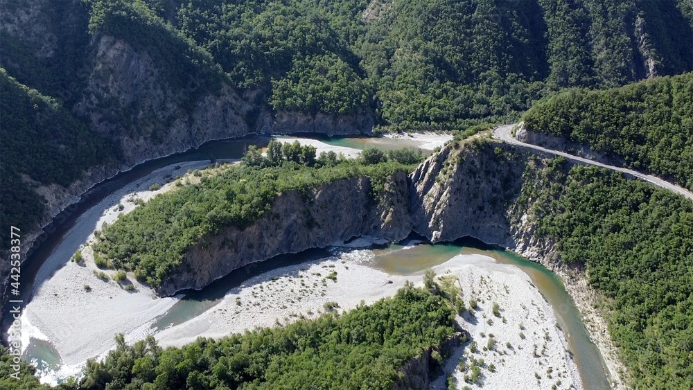Europe, Italy, Val Trebbia, Brugnello is an ancient historical village above the mountain overlooking the incredible river that reaches Bobbio - drone view of San Salvatore , the bends of the river