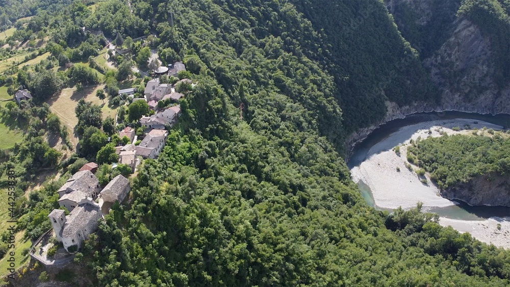 Europe, Italy, Val Trebbia, Brugnello is an ancient historical village above the mountain overlooking the incredible river that reaches Bobbio - drone view of  San Salvatore  , the bends of the river