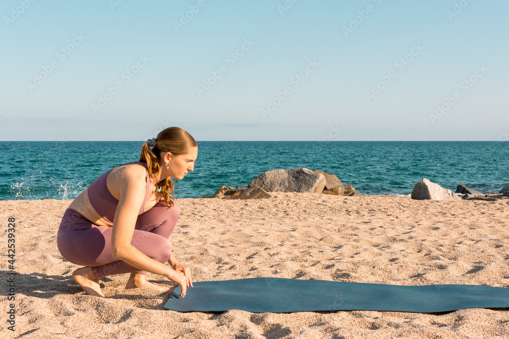 Woman preparing for yoga practice on beach Woman preparing for yoga practice on beach