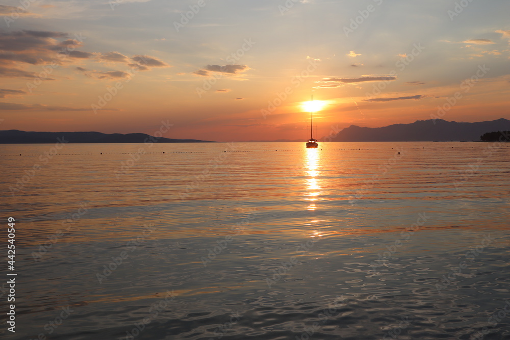 Seascape, sea at sunset, silhouette of a yacht against the background of a bright sky and calm sea on the coast of Croatia Seascape, sea at sunset, silhouette of a yacht against the background of a bright sky and calm sea on the coast of Croatia