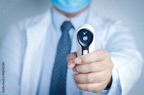 Doctors wear a mask and gloves, hold a digital thermometer to examine the patient. Healthcare service concept and medical technology. Maintain check for coronavirus