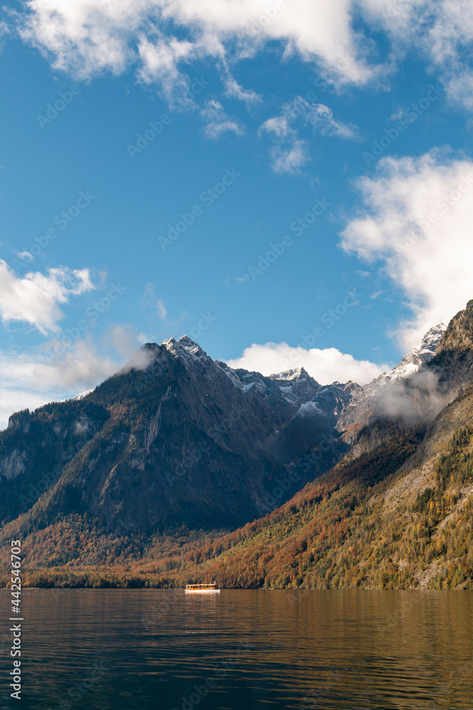 A tour boat crosses Königssee on a beautiful fall day.