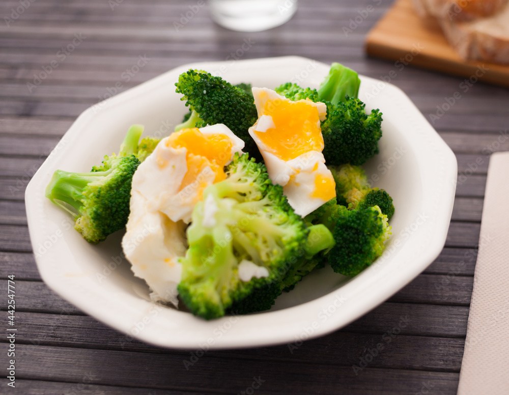 boiled broccoli inflorescences with boiled egg in plate boiled broccoli inflorescences with boiled egg in plate