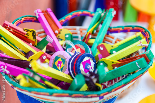 Cesta com brinquedos populares artesanais multicoloridos. Rói-rói. Mané Maluco
