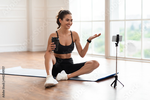 Young woman recording video blog on smartphone