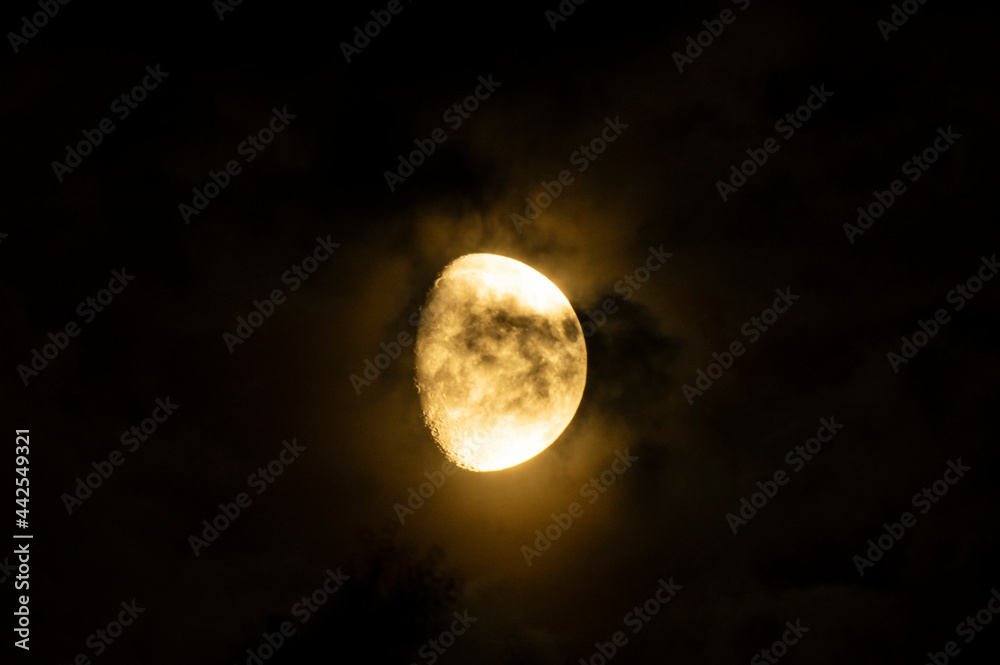Clouds and spots on the moon. Moonlight in the black night sky Clouds and spots on the moon. Moonlight in the black night sky