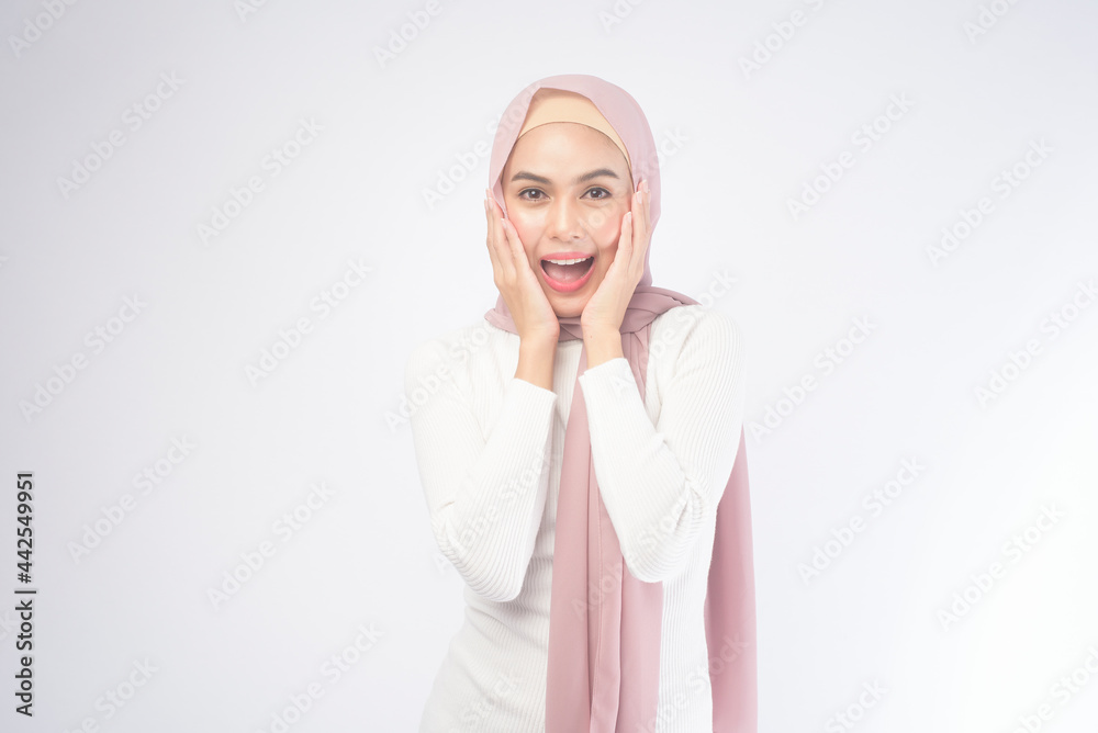 Portrait of young smiling muslim woman wearing a pink hijab over white background studio. Portrait of young smiling muslim woman wearing a pink hijab over white background studio.