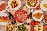 Set of popular Spanish dishes with lots of Iberian ham, salads, cured cheese, red and white wine, embuchado loin