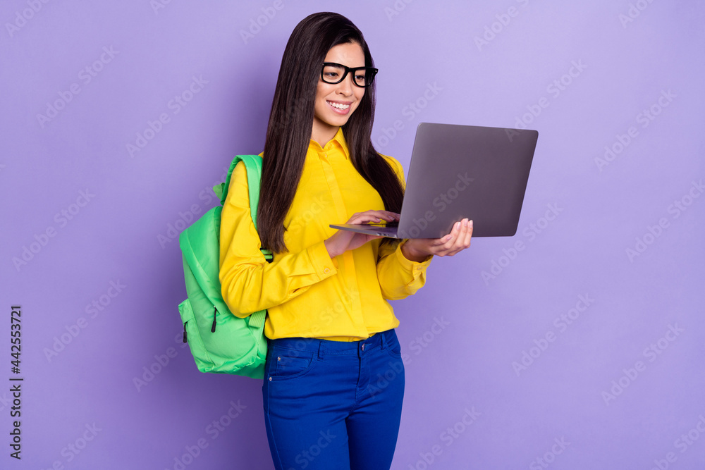 Full size photo of cheerful young nice woman look hold computer wear glasses isolated on violet color background Full size photo of cheerful young nice woman look hold computer wear glasses isolated on violet color background