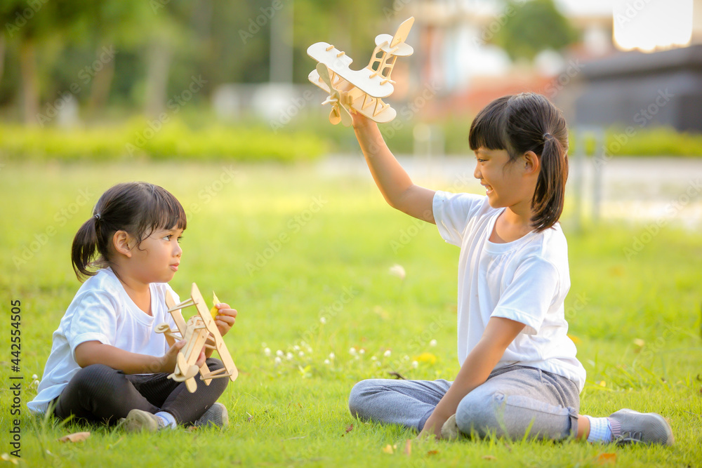 Two cute little girl asia playing toy airplane on nature in the park. Little dreams of flying limitless imagination .Which increases the development and enhances learning skills. Two cute little girl asia playing toy airplane on nature in the park. Little dreams of flying limitless imagination .Which increases the development and enhances learning skills.