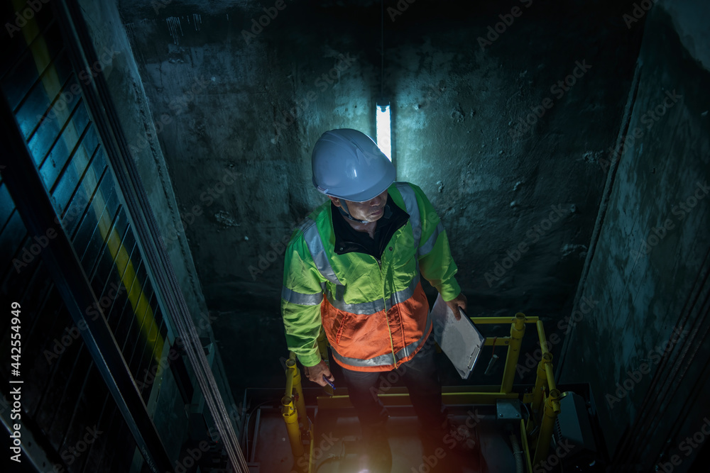 worker service check elevator. service engineer work in elevator shaft worker service check elevator. service engineer work in elevator shaft